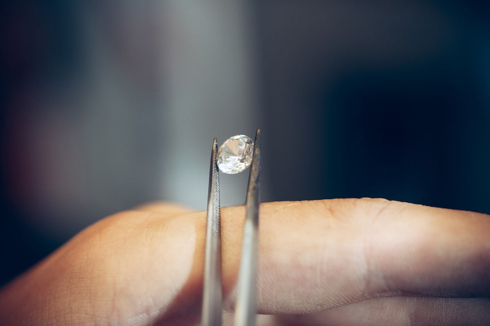 Diamante de laboratorio sujeto con pinzas