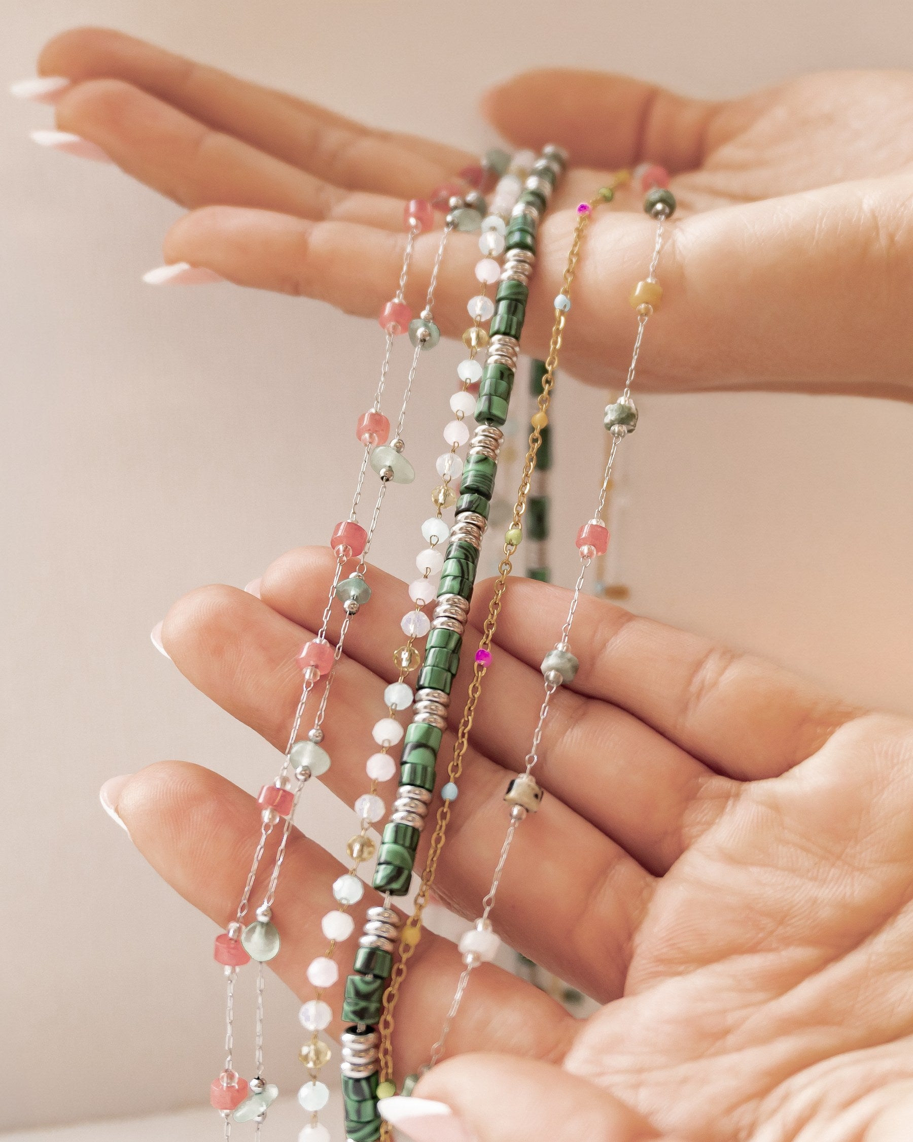 Colourful waterproof bead necklaces draped over a hand